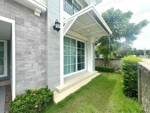 Front exterior view of a modern house with green lawn