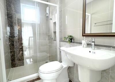 Modern bathroom with glass-enclosed shower, toilet, and sink