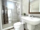 Modern bathroom with glass-enclosed shower, toilet, and sink