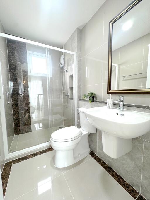 Modern bathroom with glass-enclosed shower, toilet, and sink