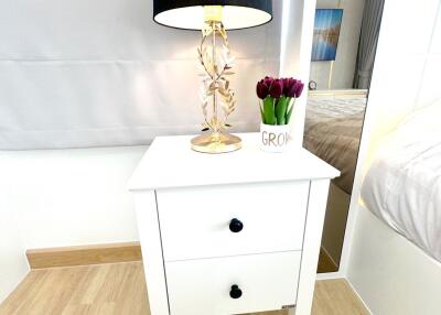 bedside table with lamp and flowers