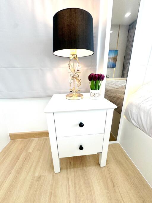 bedside table with lamp and flowers