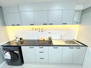 Modern kitchen with grey cabinets and black countertop