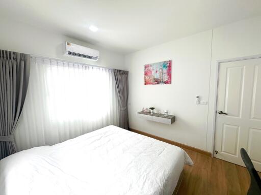 Modern bedroom with white walls and wooden flooring