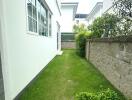 Side yard with grass and shrubs