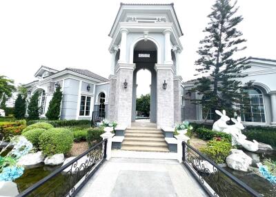 Exterior view of a luxury house with landscaped gardens and water features