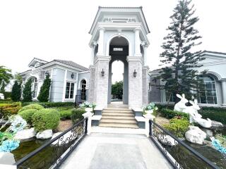 Exterior view of a luxury house with landscaped gardens and water features