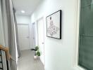 Bright hallway with framed artwork and potted plants