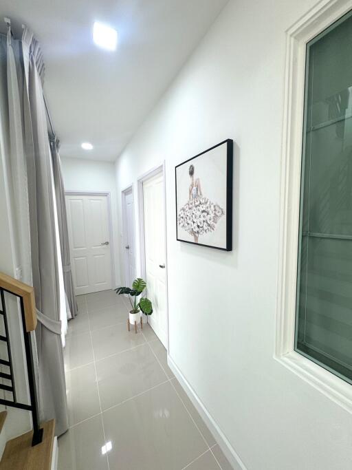 Bright hallway with framed artwork and potted plants