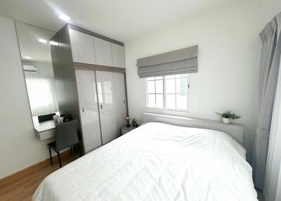 Bright bedroom with large bed, mirrored wardrobe, desk, and window