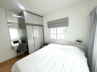 Bright bedroom with large bed, mirrored wardrobe, desk, and window