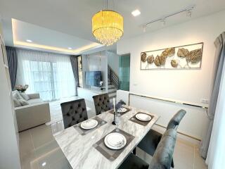 Modern dining and living area with chandelier and natural light