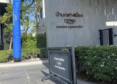 Exterior of a modern building with signage, trees, and a pathway