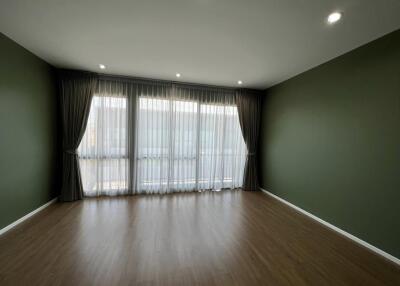 Spacious living room with large windows and hardwood floors