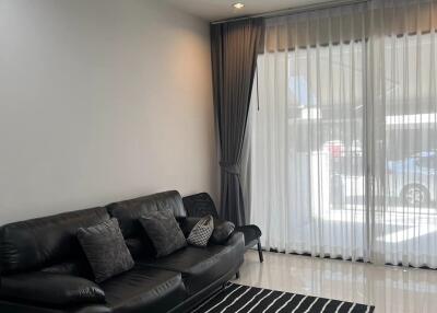 modern living room with black leather sofa and striped rug