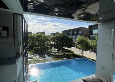 view of outdoor swimming pool with surrounding greenery and modern buildings