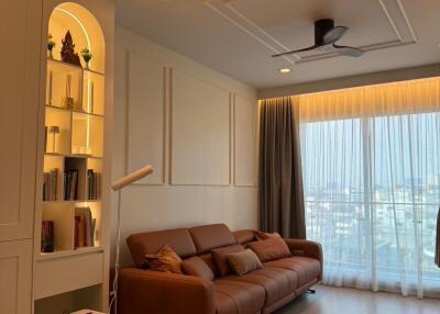 Modern living room with brown leather sofa, built-in bookshelf, and floor lamp