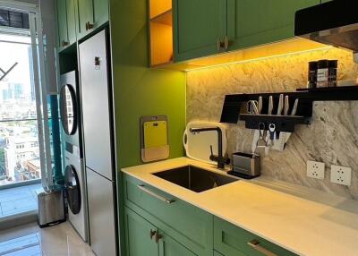 Modern kitchen with green cabinetry and built-in appliances