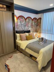 A well-decorated bedroom with a double bed, open wardrobe, and large window with sheer curtains.