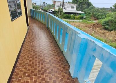 A balcony with tiled floor and blue railing