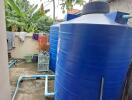 Large blue water storage tanks in an outdoor utility area