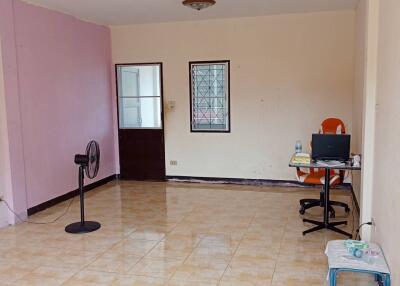 Spacious living room with tiled flooring and a simple setup