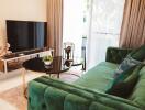 Modern living room with green velvet sofa and large TV