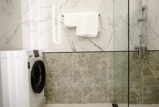 Modern bathroom with shower and laundry machine