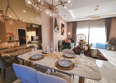 Modern dining area leading to a cozy living room with large windows