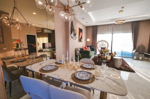 Modern dining area leading to a cozy living room with large windows