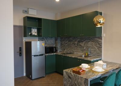 Modern kitchen with green cabinets and marble countertops