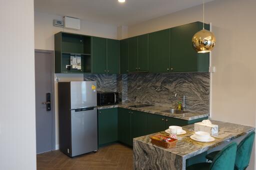 Modern kitchen with green cabinets and marble countertops