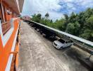 View of parking area with multiple parked cars next to an orange building