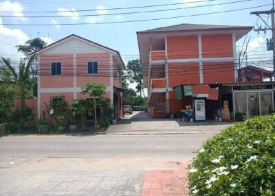 Two neighboring buildings near a sidewalk