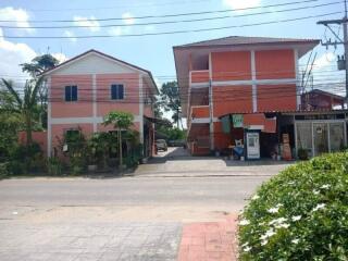 Two neighboring buildings near a sidewalk