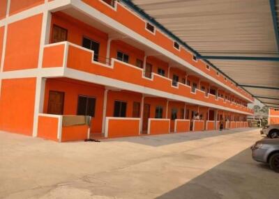 Orange multi-level apartment building with parking area