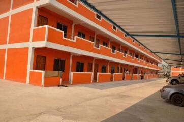 Orange multi-level apartment building with parking area