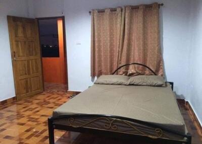 Bedroom with wooden door and large window with curtains