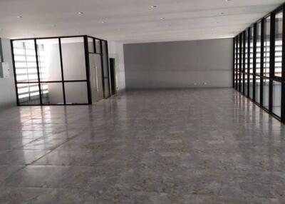 Spacious commercial space with glass partitions and marble flooring