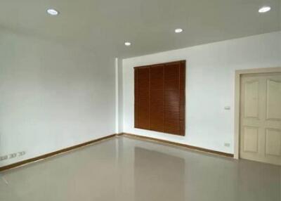 Bright empty room with recessed lighting and a window with wooden blinds