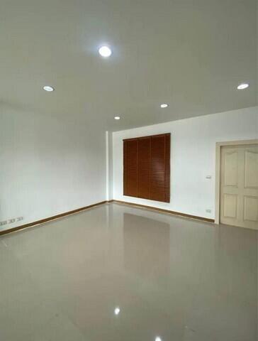 Bright empty room with recessed lighting and a window with wooden blinds