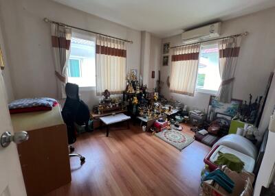 Bedroom with wooden floor, desk, and various decorations