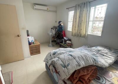 Well-lit bedroom with bed, windows, and storage