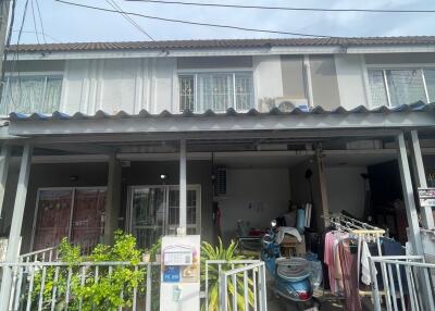 Two-story townhouse exterior with covered garage and garden