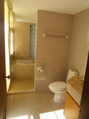 Well-lit bathroom with tub and toilet