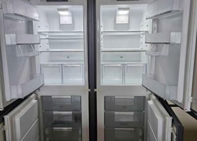 Open double-door refrigerator with empty shelves