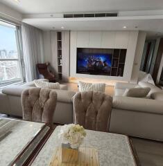 Modern living room with a large TV and city view