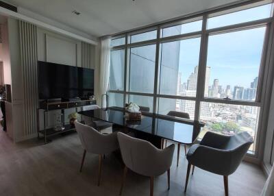 Modern living and dining area with large windows and city view