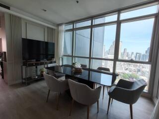 Modern living and dining area with large windows and city view