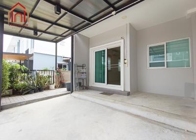 Covered patio area with sliding glass door and potted plants